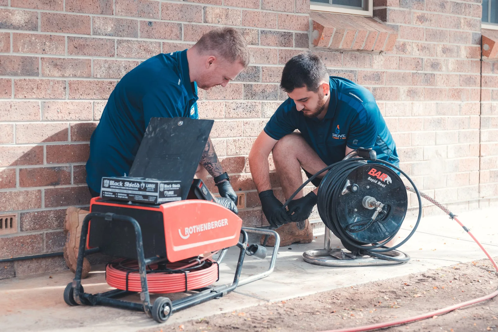 Grove plumbers investigating a drain with camera equipment